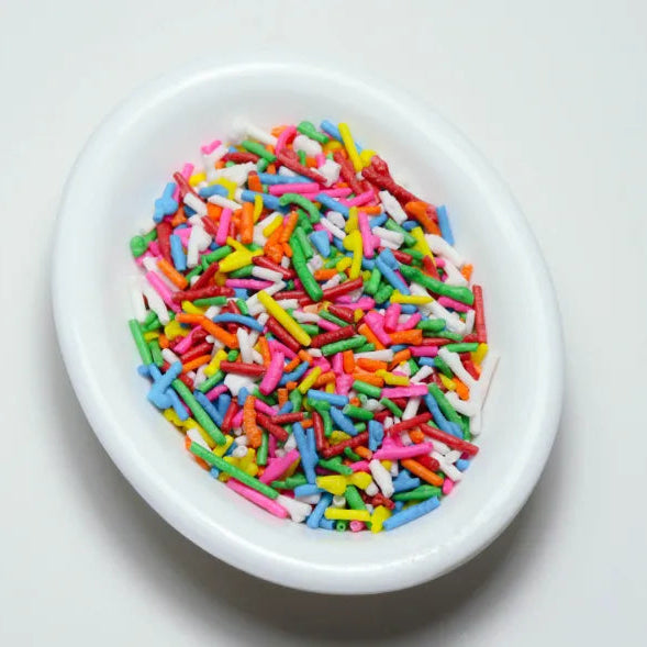 Variedad de grageas comestibles en diferentes colores y tamaños para decoración de repostería. Paquetes de 50 gramos de chispas dulces para tortas y cupcakes.