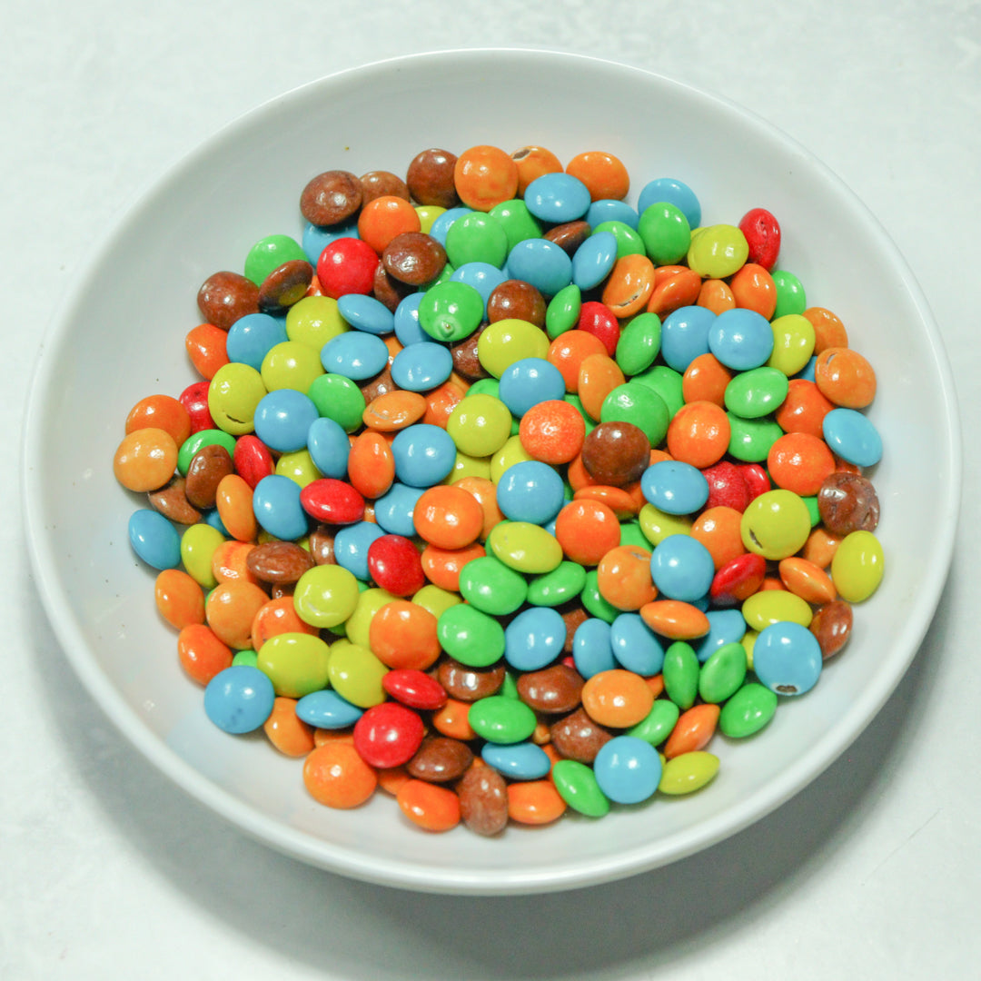 Grageas comestibles coloridas en paquete de 50g para decoración de tortas, cupcakes y galletas. Variedad de colores y tamaños para repostería profesional.