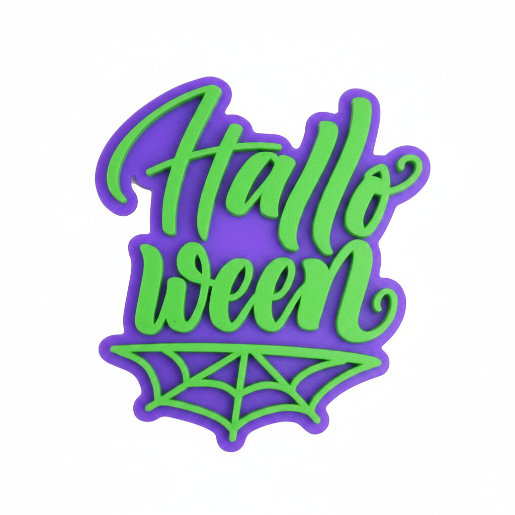 Sello embosser Vallia Repostería de Halloween con texto en relieve verde sobre base morada y diseño de telaraña