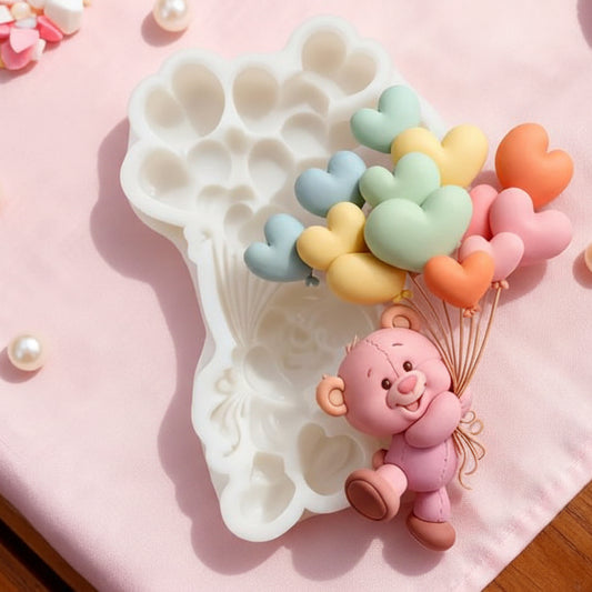 Molde de silicona blanco con diseño de osito abrazando globos en forma de corazón, medidas de 9.5 cm x 6.8 cm, ideal para decoraciones de repostería y manualidades.