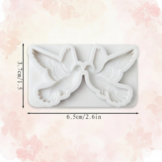 Detalle de cavidades de molde de silicona palomas con relieve de plumas para decoración de tortas y cupcakes en eventos religiosos


