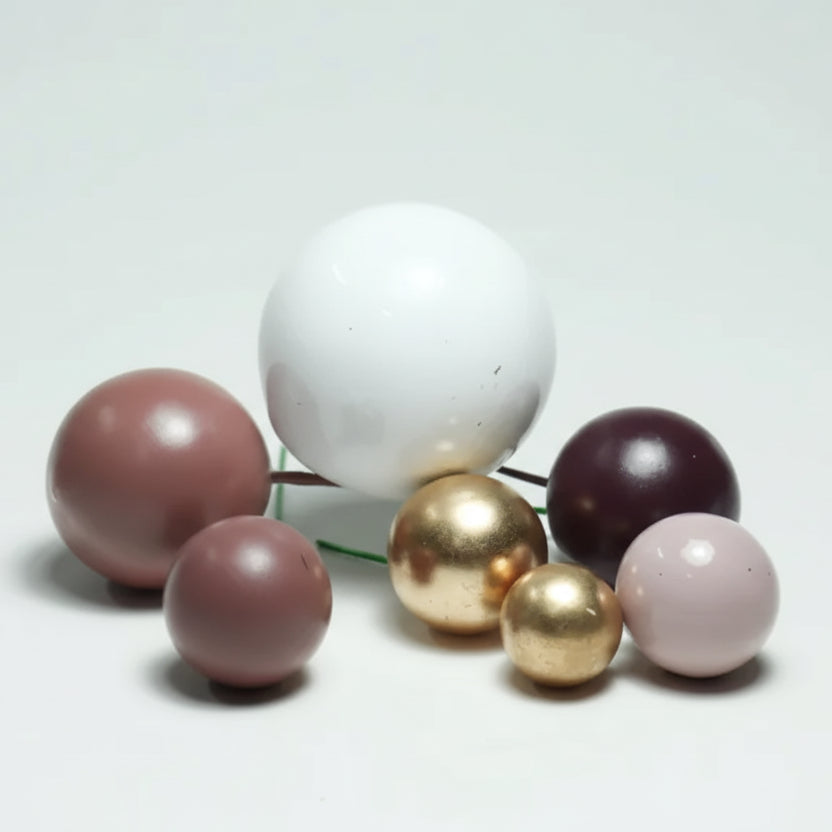 Cascada de mini globos decorativos en tonos pasteles sobre una torta de cumpleaños - Vallia Repostería