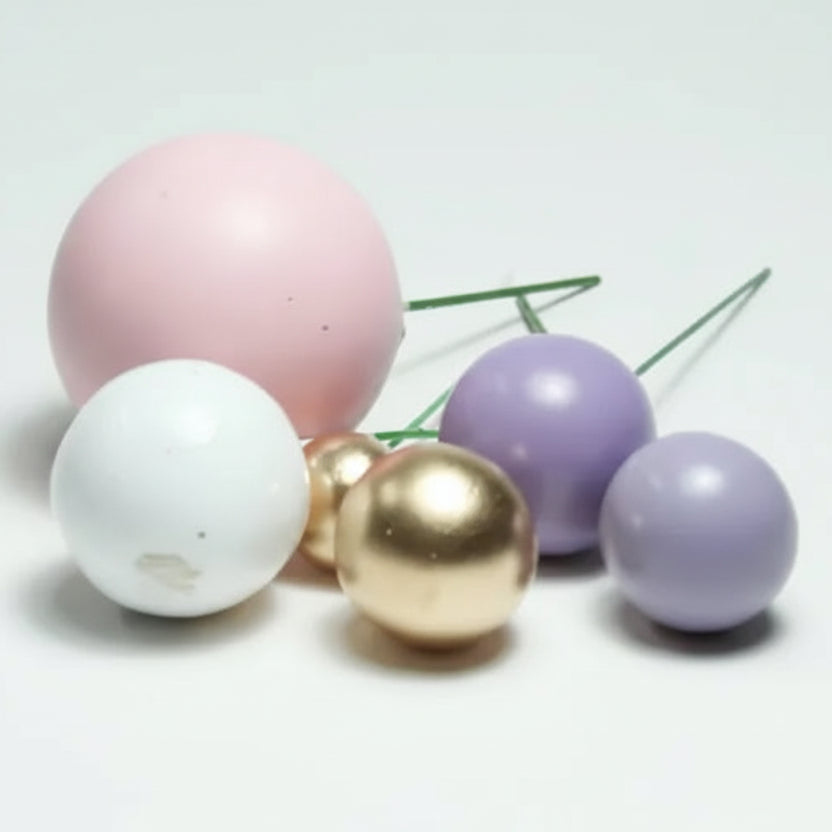 Cascada de mini globos decorativos en tonos pasteles sobre una torta de cumpleaños - Vallia Repostería