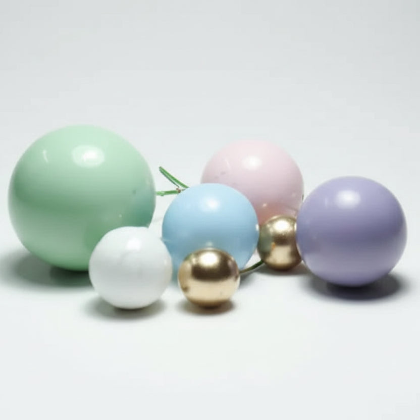 Cascada de mini globos decorativos en tonos pasteles sobre una torta de cumpleaños - Vallia Repostería