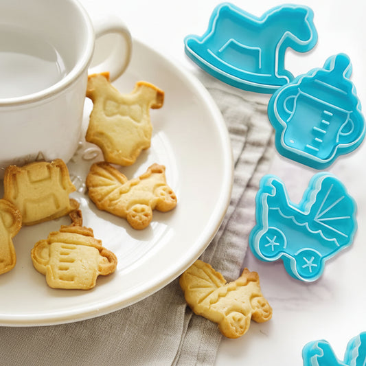 Kit de cortadores push azules y piezas de fondant decoradas con sello de caballito mecedor, tetero, ropa de bebé y coche para eventos infantiles.