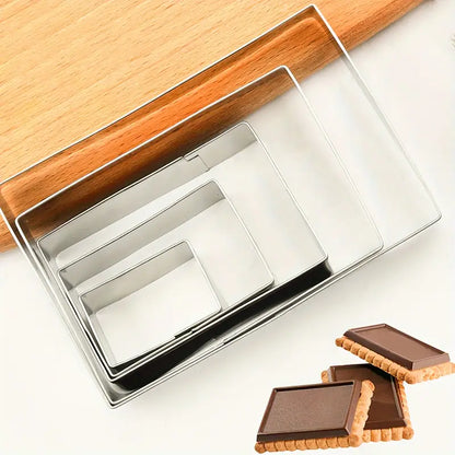 Juego de 5 cortadores rectangulares de acero inoxidable anidados en caja transparente junto a rodillo de madera y galletas rectangulares con chocolate - Vallia Reposteria