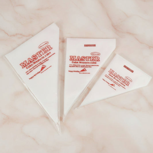 Tres mangas pasteleras desechables MASTER tamaños S M y L sobre fondo mármol rosa – paquete x10 unidades para decoración de tortas y repostería - Vallia Reposteria