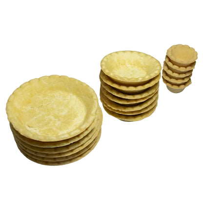 Bases para tartaleta Vallia Repostería con bordes ondulados, apiladas en tres tamaños sobre fondo de mármol blanco.
