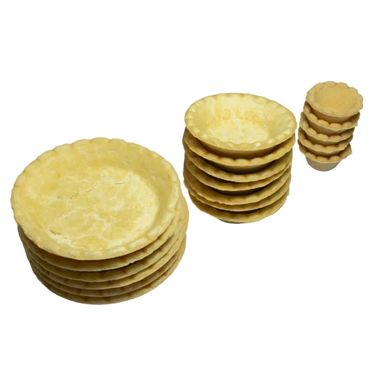 Bases para tartaleta Vallia Repostería con bordes ondulados, apiladas en tres tamaños sobre fondo de mármol blanco.