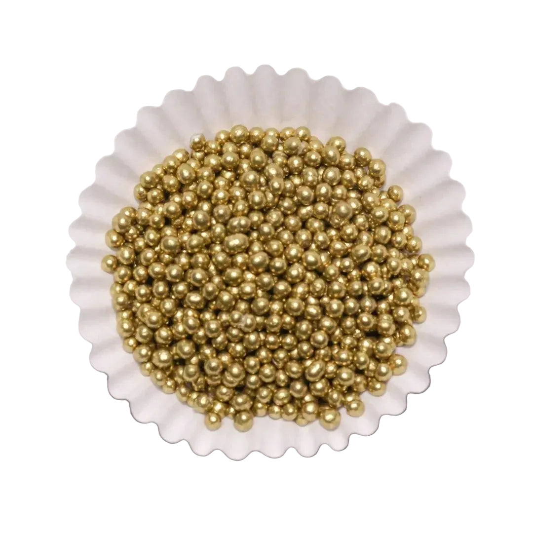 Grageas comestibles doradas de Vallia Repostería en un capacillo blanco para decorar pasteles y postres.