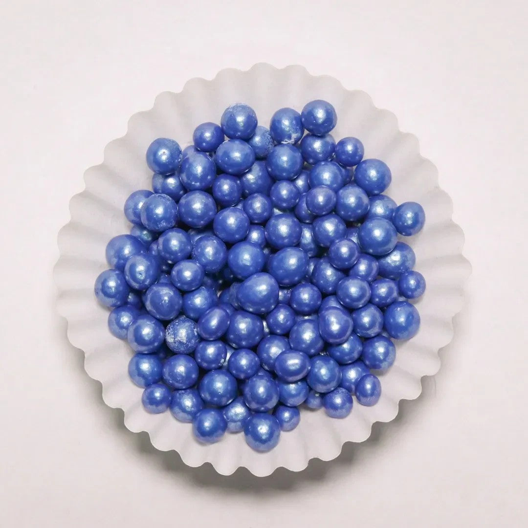 Grageas perladas comestibles azules de Vallia Repostería en un capacillo blanco para decorar postres y tortas