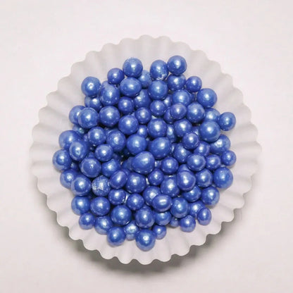 Grageas perladas comestibles azules de Vallia Repostería en un capacillo blanco para decorar postres y tortas