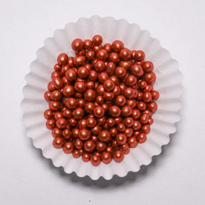 Grageas perladas comestibles rojas de Vallia Repostería en un capacillo blanco para decorar postres y tortas.