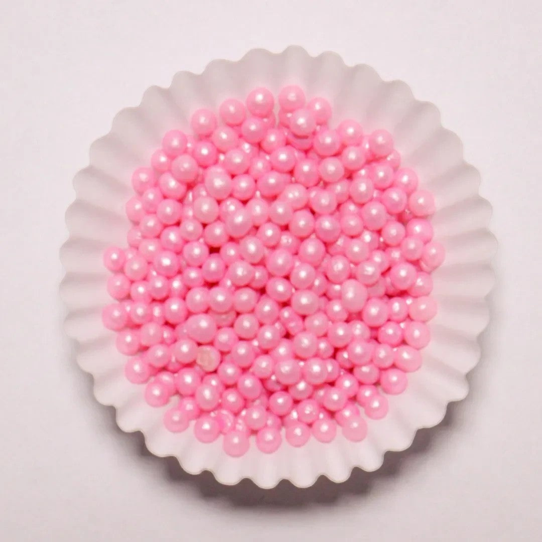 Grageas perladas comestibles rosadas de Vallia Repostería en un capacillo blanco para decorar postres y tortas.