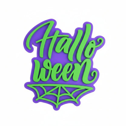 Sello embosser Vallia Repostería de Halloween con texto en relieve verde sobre base morada y diseño de telaraña